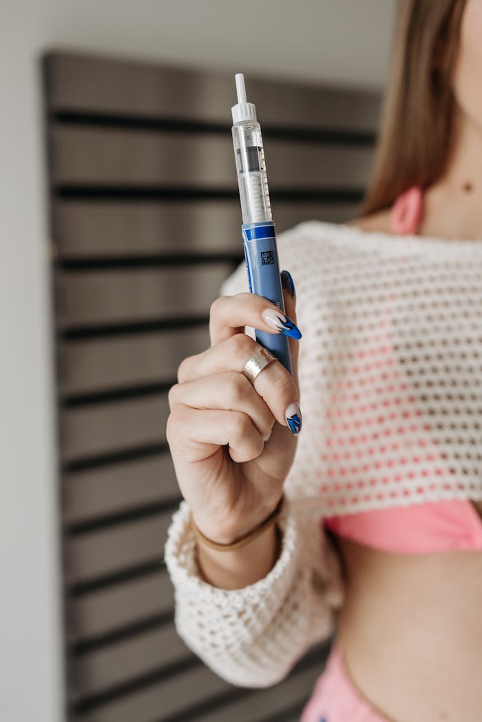 Services-01 Close-up of a woman holding an insulin pen, emphasizing diabetes care.